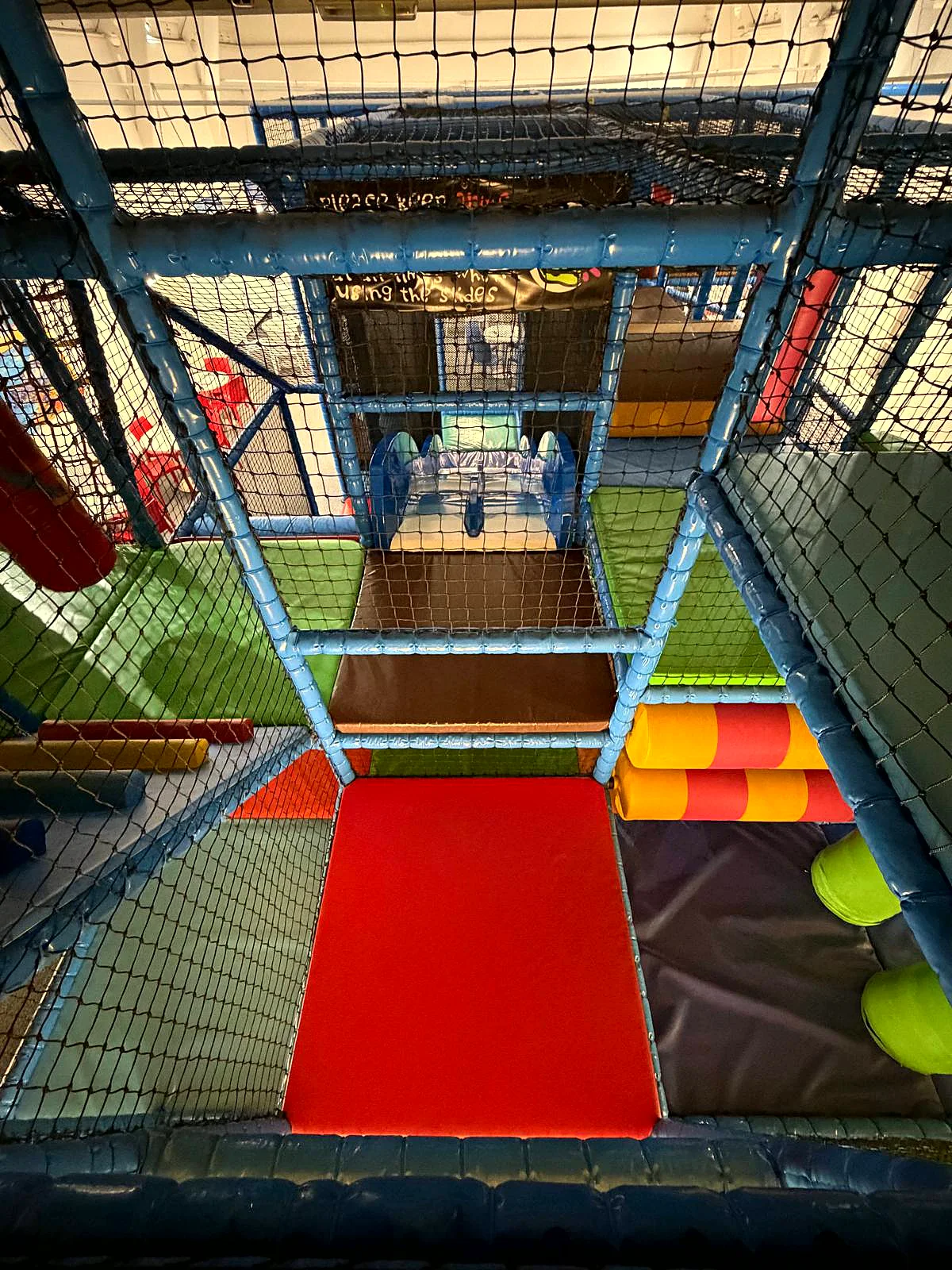 Inside the multi-level play frame at Captain Ted's, with the big red slide