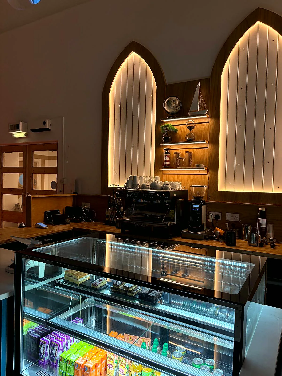 The caf&eacute; counter beneath the arched, backlit alcove