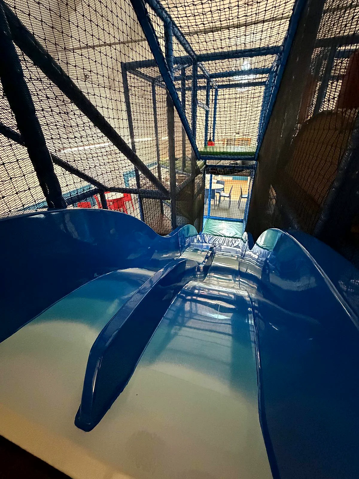 Racing down the blue slide in the play frame