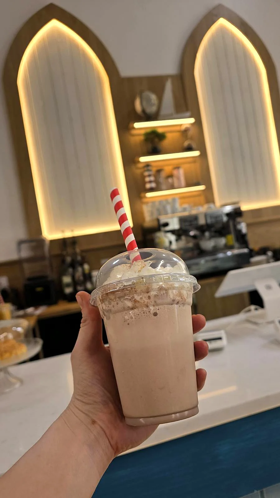 Holding a milkshake in the caf&eacute;